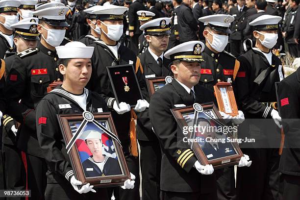 Surviving sailors of the sunken navy ship Cheonan carry the portraits of the deceased sailors of the sunken South Korean naval vessel Cheonan during...