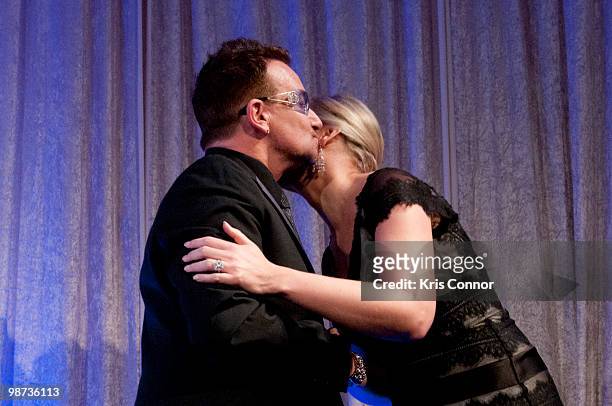 Frontman Bono kisses a presenter after being awarded the Distinguished Humanitarian Leadership Award during the 2010 Atlantic Council awards dinner...
