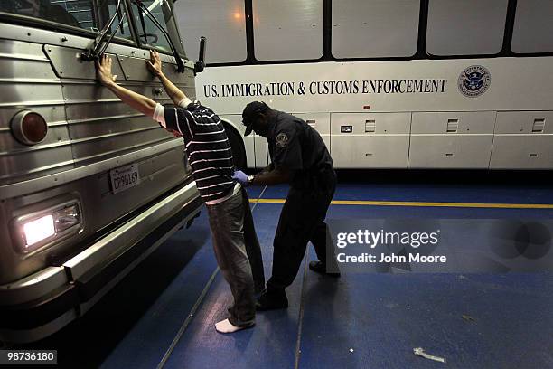 An undocumented Mexican immigrant is searched while being in-processed at the Immigration and Customs Enforcement , center on April 28, 2010 in...