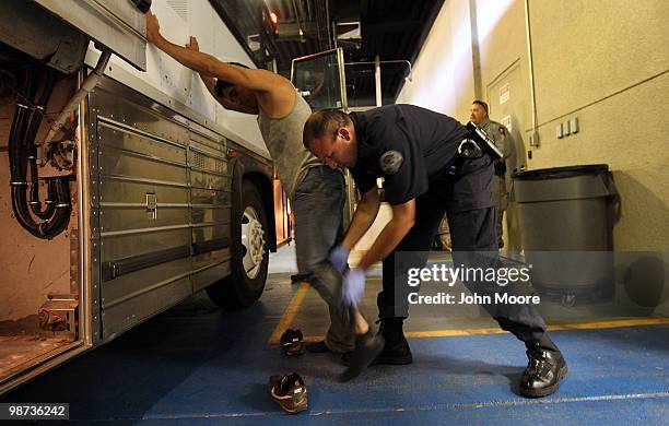 An undocumented Mexican immigrant is searched while being in-processed at the Immigration and Customs Enforcement , center on April 28, 2010 in...