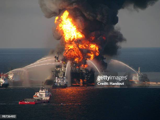 In this handout image provided be the U.S. Coast Guard, fire boat response crews battle the blazing remnants of the off shore oil rig Deepwater...