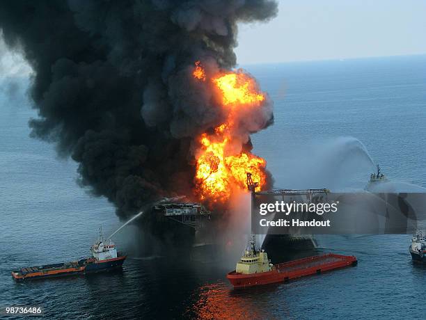 In this handout image provided be the U.S. Coast Guard, fire boat response crews battle the blazing remnants of the off shore oil rig Deepwater...