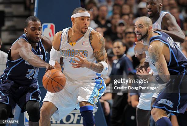 Kenyon Martin of the Denver Nuggets has the ball knocked away by Paul Millsap of the Utah Jazz as Carlos Boozer of the Jazz and Johan Petro of the...