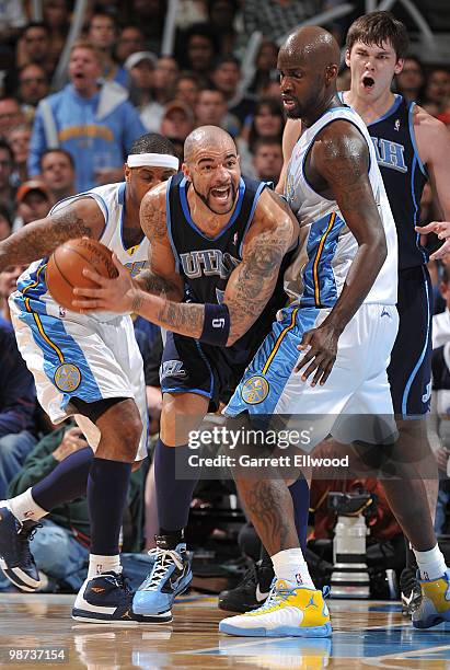 Carlos Boozer of the Utah Jazz looks to pass against Johan Petro of the Denver Nuggets in Game Five of the Western Conference Quarterfinals during...