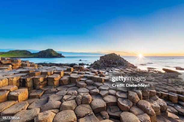 puesta de sol sobre la calzada del gigante, irlanda del norte - irlanda fotografías e imágenes de stock