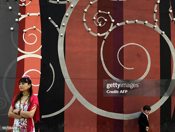 Woman wearing a traditional Sevillana dress attend on April 24, 2010 the Feria de Abril in Seville. The feria attracts thousands of tourists, despite...