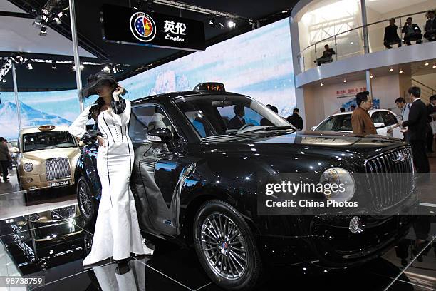 Chinese model poses in front of a London Black Cab manufactured by Chinese car maker Geely at the Beijing Auto Show on April 29, 2010 in Beijing,...