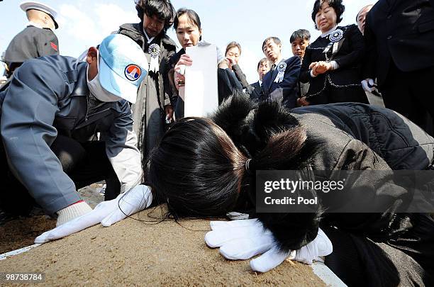 Relatives of a deceased sailor of the sunken South Korean naval vessel Cheonan cries as she touches grave during the funeral ceremony at the Daejeon...