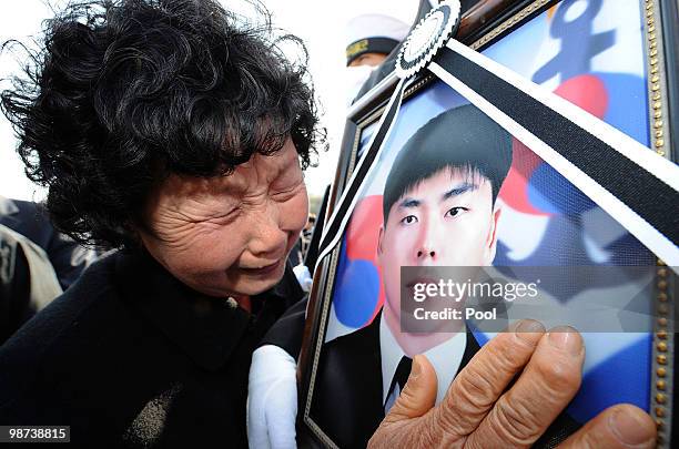 Relative of a deceased sailor of the sunken South Korean naval vessel Cheonan cries as she touches portrait during the funeral ceremony at the...
