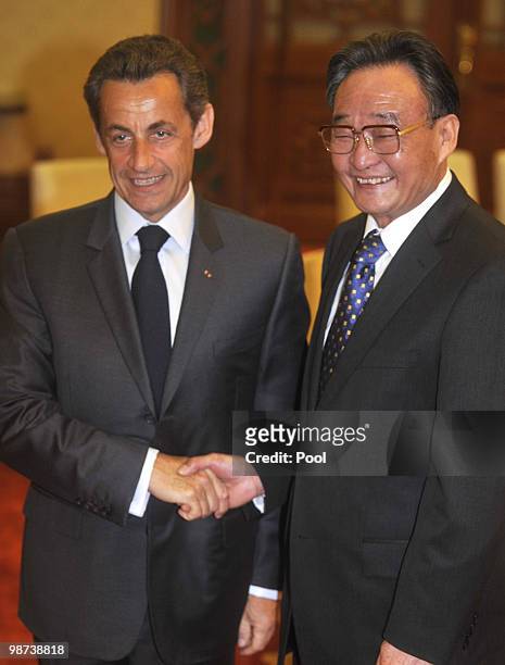 France's President Nicolas Sarkozy shakes hands with National People's Congress Standing Committee Chairman Wu Bangguo at the Great Hall of the...