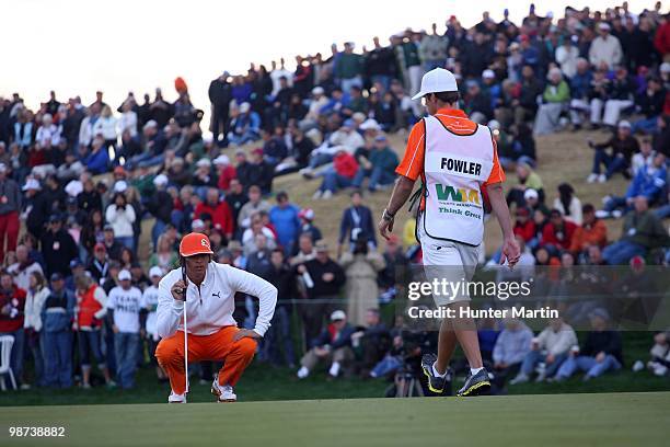 Rickie Fowler lines up a putt alongside his caddie during the final round of the Waste Management Phoenix Open at TPC Scottsdale on February 28, 2010...