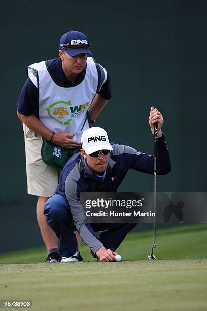 Hunter Mahan lines up his putt with the help of his caddie during the final round of the Waste Management Phoenix Open at TPC Scottsdale on February...