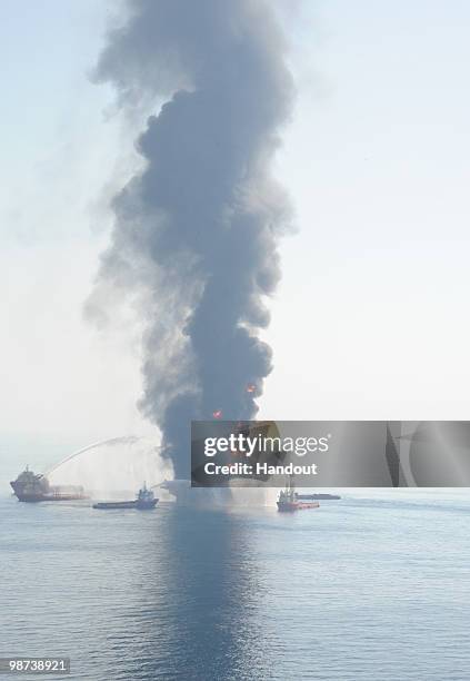 In this handout image provided by the U.S. Coast Guard, Assist vessels fire water cannons at the Deepwater Horizon in an attempt to control and...