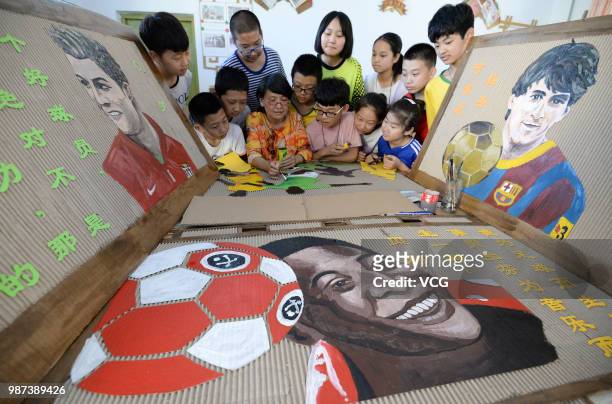 Teacher and her students make World Cup-themed handicrafts on discarded corrugated cardboards on June 27, 2018 in Handan, Hebei Province of China....