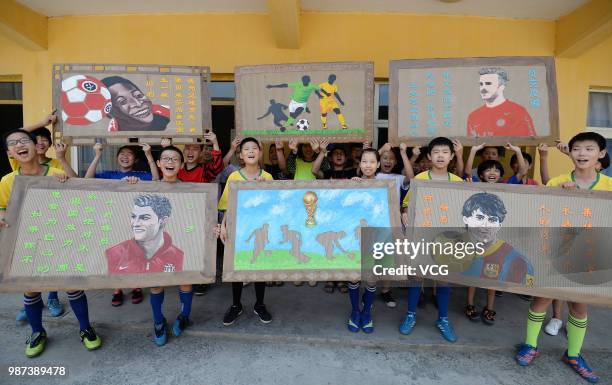 Students show their World Cup-themed handicrafts on discarded corrugated cardboards on June 27, 2018 in Handan, Hebei Province of China. A teacher...