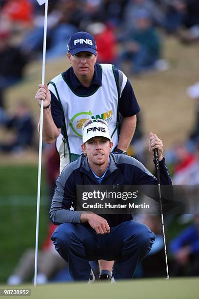 Hunter Mahan lines up a putt alongside his caddie during the final round of the Waste Management Phoenix Open at TPC Scottsdale on February 28, 2010...