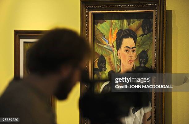 Camaraman standing in front of the painting "Self-Portrait with Monkey" by Mexican artist Frida Kahlo takes pictures during a press preview on April...