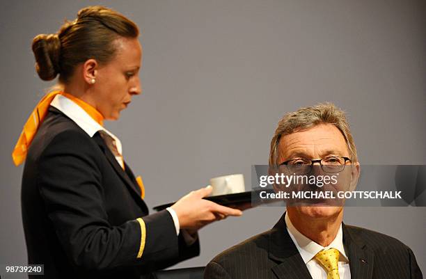 An air hostess offers a cup of coffee to Lufthansa CEO Wolfgang Mayrhuber prior to the company's annual general assembly on April 29, 2010 at the...