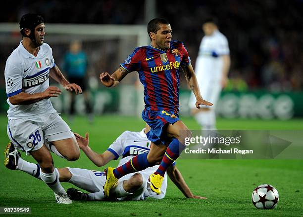 Daniel Alves of Barcelona is fouled by Thiago Motta and Cristian Chivu of Inter Milan during the UEFA Champions League Semi Final Second Leg match...