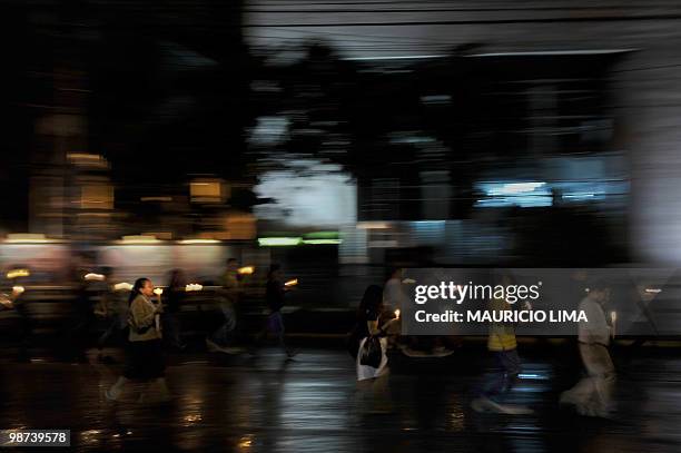 Supporters of ousted Honduran president Manuel Zelaya hold candles as they march towards the Brazilian embassy late October 6, 2009 in Tegucigalpa,...