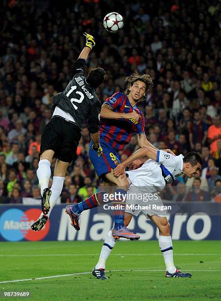 Julio Cesar of Inter Milan punches clear of team mate Lucio and Zlatan Ibrahimovic of Barcelona during the UEFA Champions League Semi Final Second...