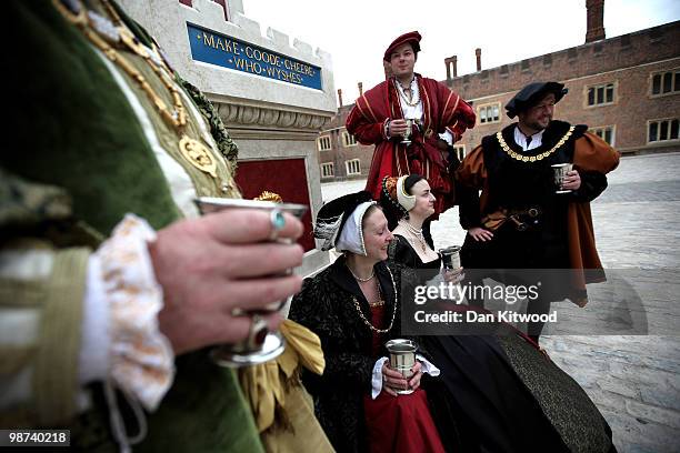 Actors dressed in historical costume gather around the newly unveiled wine fountain in the inner courtyard at Hampton Court Palace on April 29, 2010...