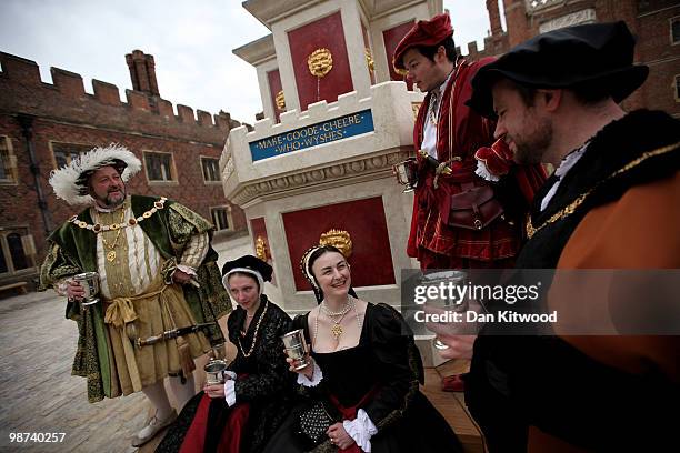 Actors dressed in historical costume gather around the newly unveiled wine fountain in the inner courtyard at Hampton Court Palace on April 29, 2010...