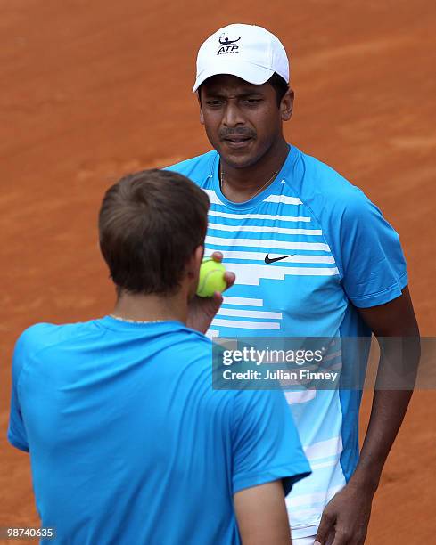 Max Mirnyi of Belarus and Mahesh Bhupathi of India talk tactics in their doubles match against John Isner and Sam Querrey of USA during day five of...