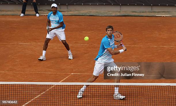Max Mirnyi of Belarus and Mahesh Bhupathi of India in action in their doubles match against John Isner and Sam Querrey of USA during day five of the...