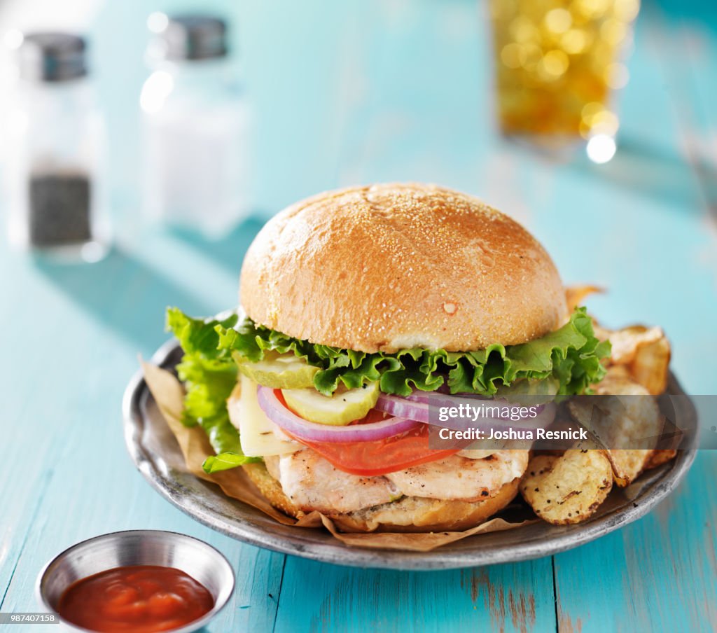 Grilled chicken sandwich on rustic painted table top