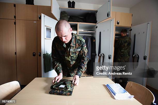 The young recruit Koenig of the German Bundeswehr is folding a shirt in his living room during his nine months military service at the Julius Leber...