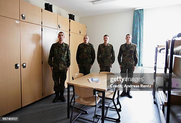 The young recruits Witzig, Koenig, Schirmer and Gaburek of the German Bundeswehr stand at attention in an honour guard in their living room during...