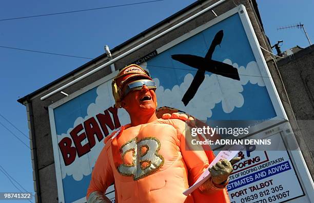 Captain Beany, leader of the New Millennium Bean Party, poses for pictures in front of his party's election billboard in Port Talbot, Wales, on April...