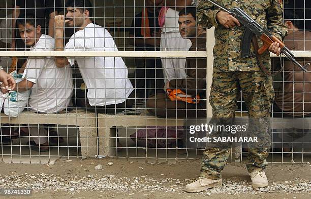 An Iraqi soldier stands guard in front of prisoners waiting to be released from Al-Rusafa detention facility in Baghdad on April 29, 2010. About 120...
