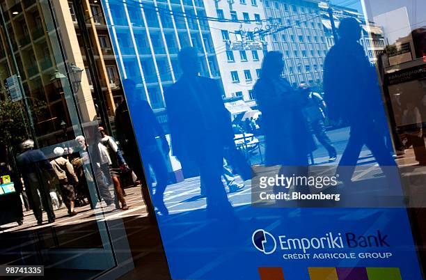 Pedestrians walk past a branch of Emporiki bank in Athens, Greece, on Thursday, April 29, 2010. Credit Agricole SA and Societe Generale SA may be...