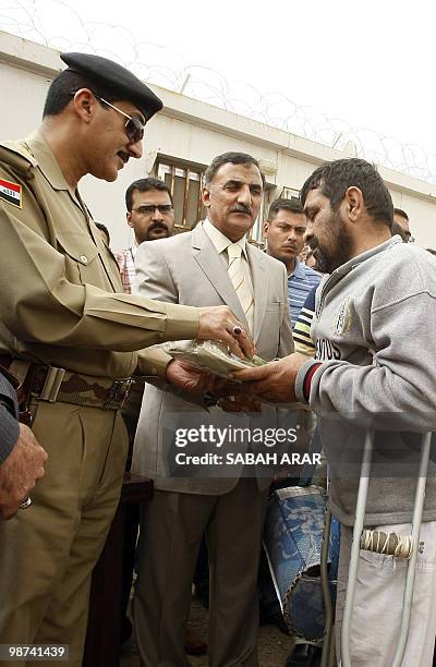 Baghdad's security spokesman, Major General Qassim Atta , hands a package to a prisoner released from Al-Rusafa detention facility in Baghdad on...