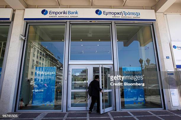 Pedestrian enters a branch of Emporiki bank in Athens, Greece, on Thursday, April 29, 2010. Credit Agricole SA and Societe Generale SA may be among...