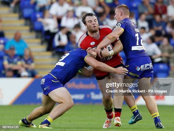 Salford Red Devils' Greg Burke is tackled by Warrington Wolves' George King and Jack Hughes during the Betfred Super League match at Halliwell Jones...