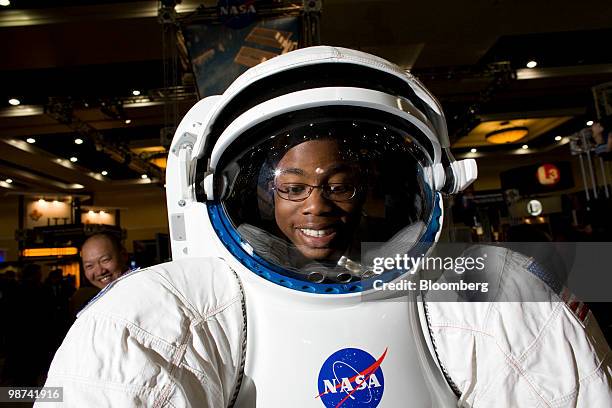 Eric Carter, 13 years old, looks through the Mark III suit for planetary exploration at the NASA booth at the 26th National Space Symposium in...