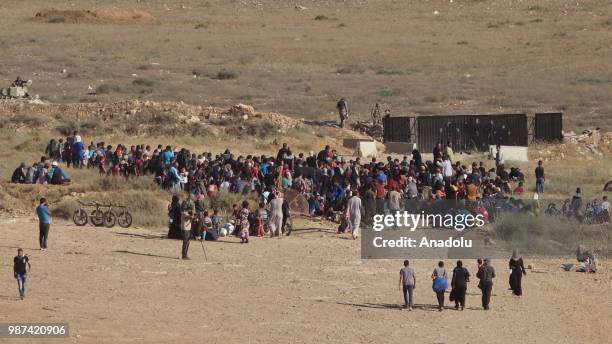 Syrians wait at the border areas near Jordan after they fled from the ongoing military operations by Bashar al-Assad regime and its allies in Syrias...