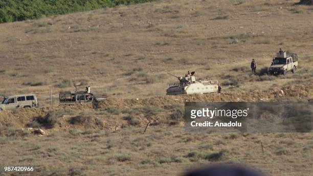 Armored vehicles are seen as Syrians wait at the border areas near Jordan after they fled from the ongoing military operations by Bashar al-Assad...