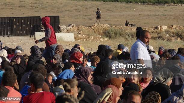 Syrians wait at the border areas near Jordan after they fled from the ongoing military operations by Bashar al-Assad regime and its allies in Syrias...