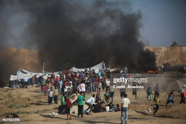 Palestinian protestors run away after Israeli forces fire tear gas on the 14th week of right of return march near Al Bureij Refugee Camp on the...