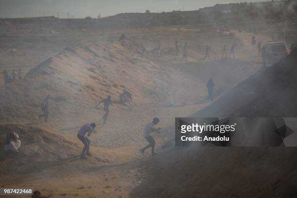 Palestinian protestors run away after Israeli forces fire tear gas on the 14th week of right of return march near Al Bureij Refugee Camp on the...