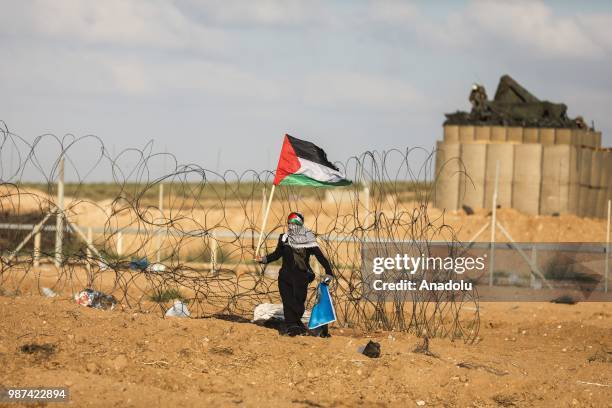 Palestinian protestors run away after Israeli forces fire tear gas along the border between the Gaza Strip and Israel on the 14th week of right of...