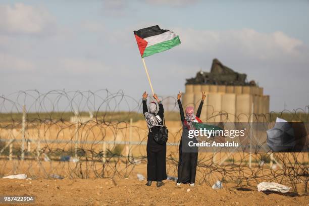 Palestinian protestors run away after Israeli forces fire tear gas along the border between the Gaza Strip and Israel on the 14th week of right of...