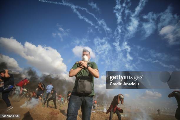 Palestinian protestors run away after Israeli forces fire tear gas along the border between the Gaza Strip and Israel on the 14th week of right of...