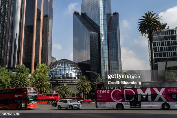 Tour buses pass in front of the Bolsa Mexicana de Valores SAB, Mexico's stock exchange, in Mexico City, Mexico, on Friday, June 29, 2018. With just...