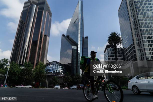 Person rides a bicycle in front of the Bolsa Mexicana de Valores SAB, Mexico's stock exchange, in Mexico City, Mexico, on Friday, June 29, 2018. With...