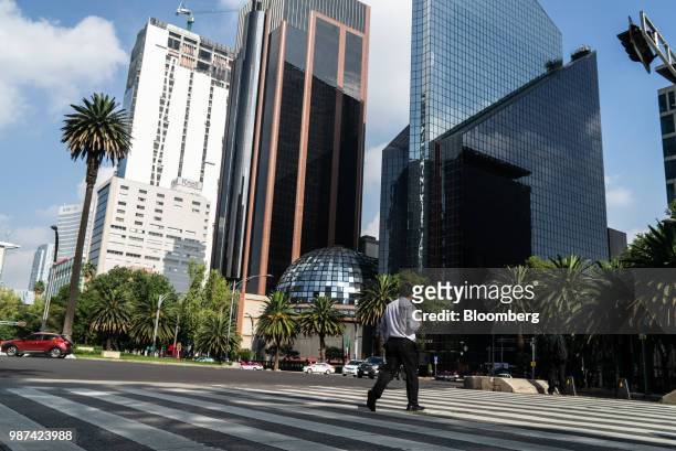 Pedestrian crosses a street in front of the Bolsa Mexicana de Valores SAB, Mexico's stock exchange, in Mexico City, Mexico, on Friday, June 29, 2018....